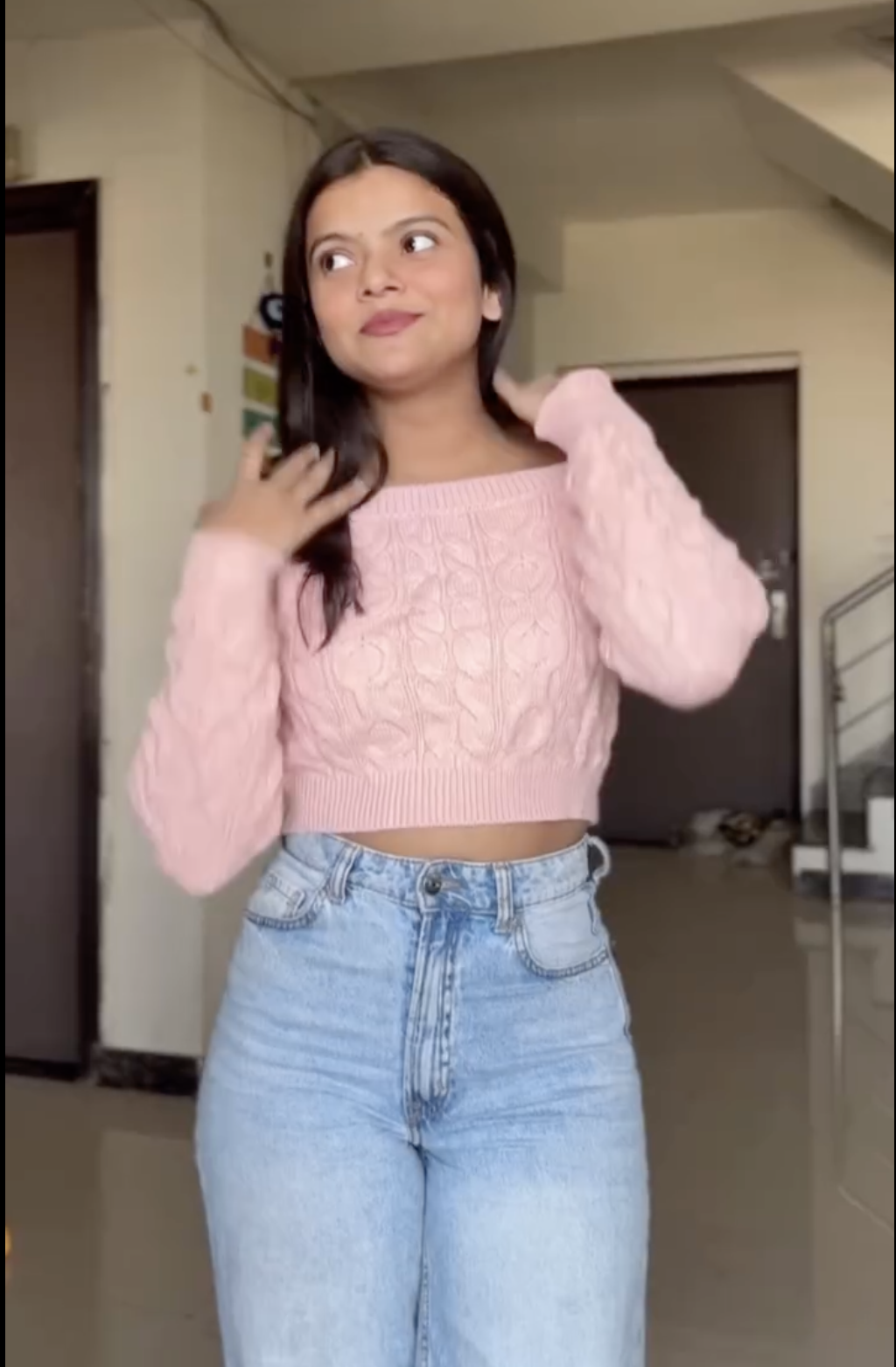 Young Woman in a Playful Pose Wearing a Pink Sweater - Image 2