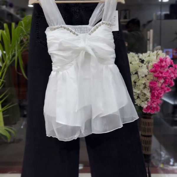 ✨ Elegant & Chic: White Sleeveless Organza Ruffled Top with Embellished Neckline & Dark Trousers 👗